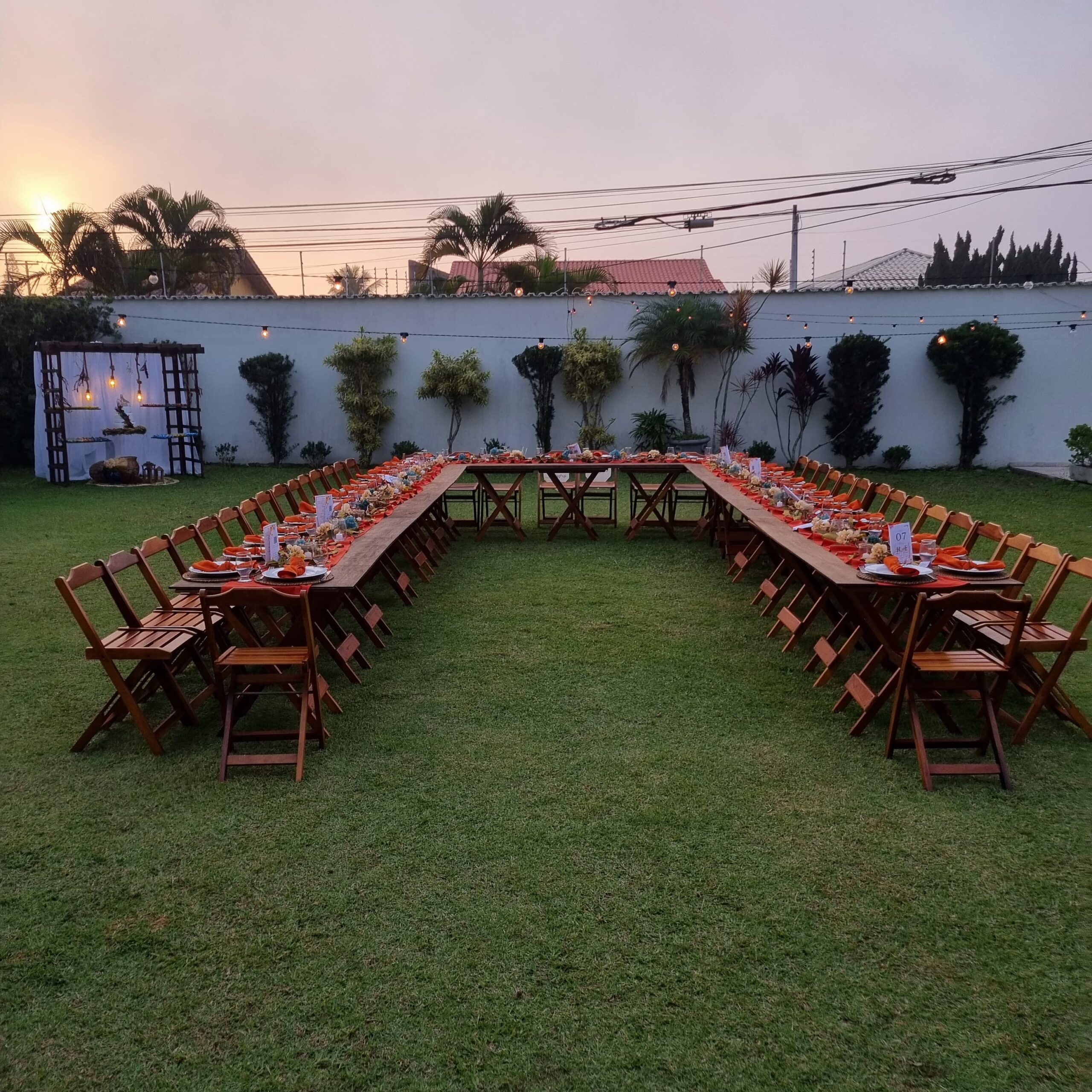 Mesa posta ao ar livre para jantar de confraternização ao pôr do sol